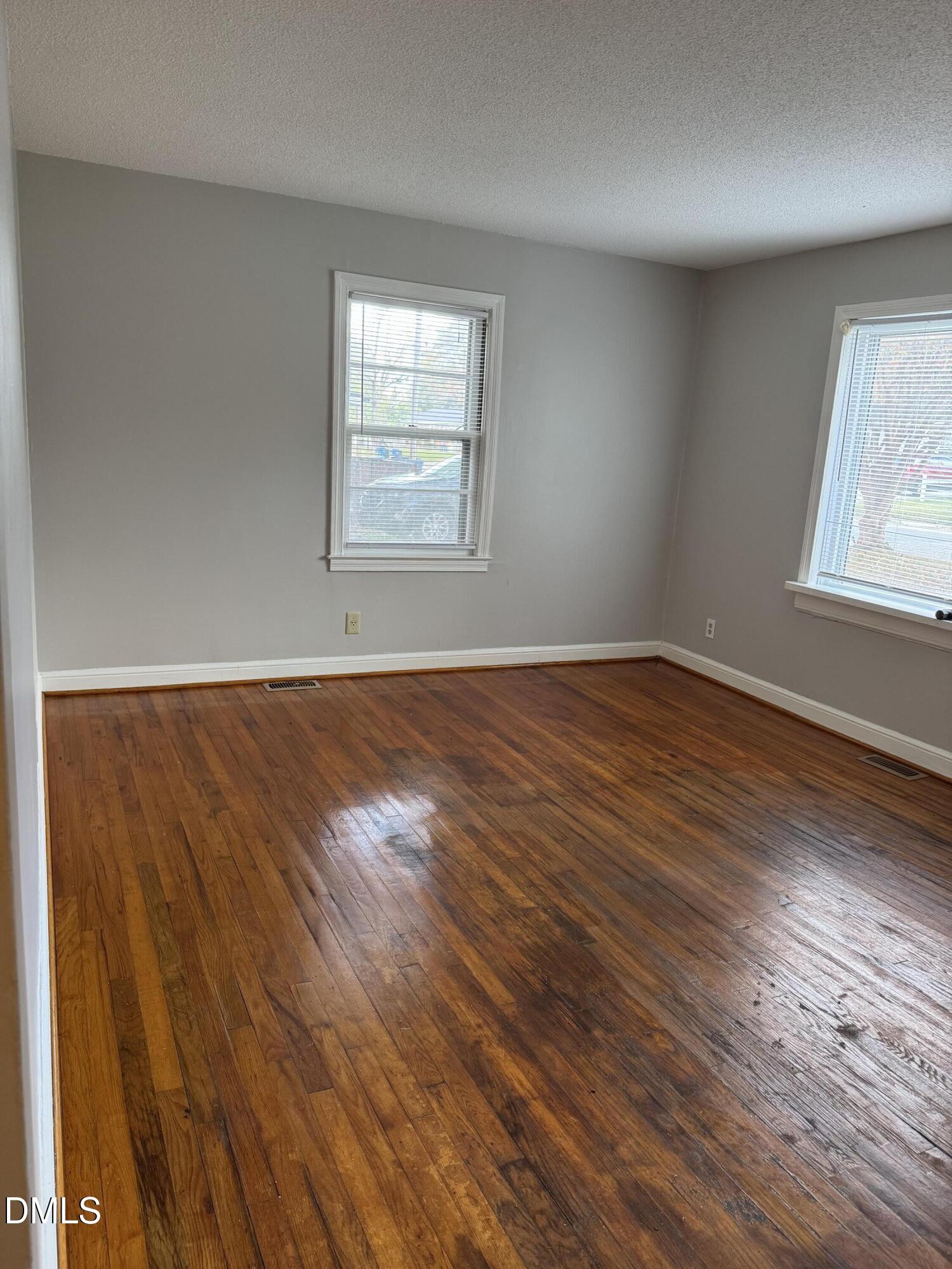 101 Joy Street Dunn, NC 28334 - Photo 7 of 14 an empty room with wooden floor and windows