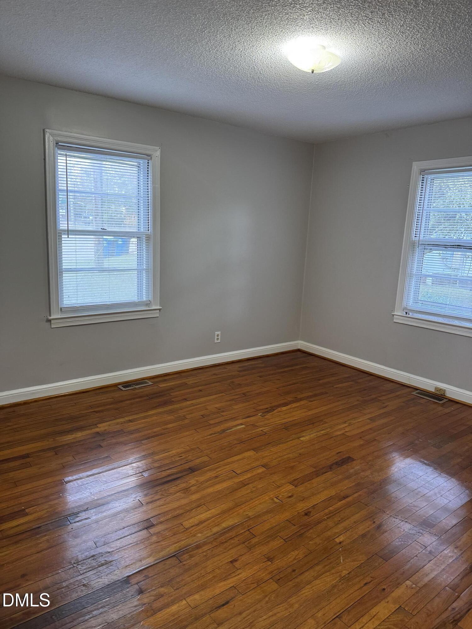 101 Joy Street Dunn, NC 28334 - Photo 10 of 14 an empty room with wooden floor and windows