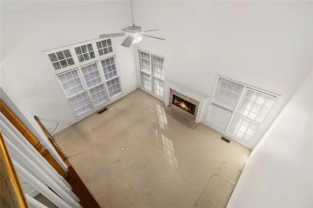 an empty room with windows and fan