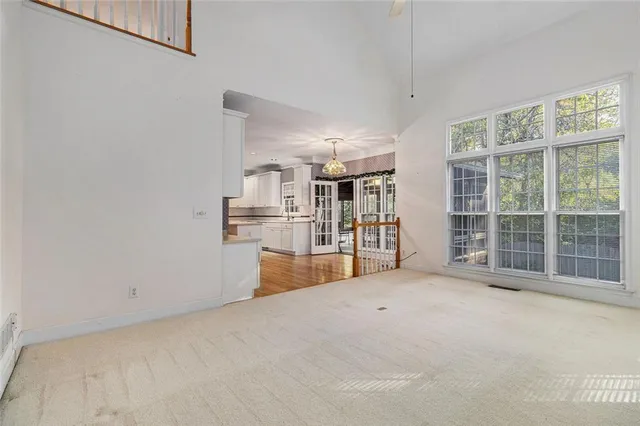 a view of an empty room with wooden floor and a fireplace