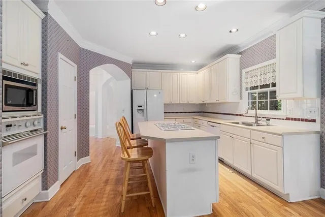 a kitchen with stainless steel appliances kitchen island granite countertop a sink and cabinets