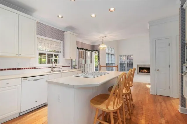 a large kitchen with kitchen island a stove a sink a dining table and chairs