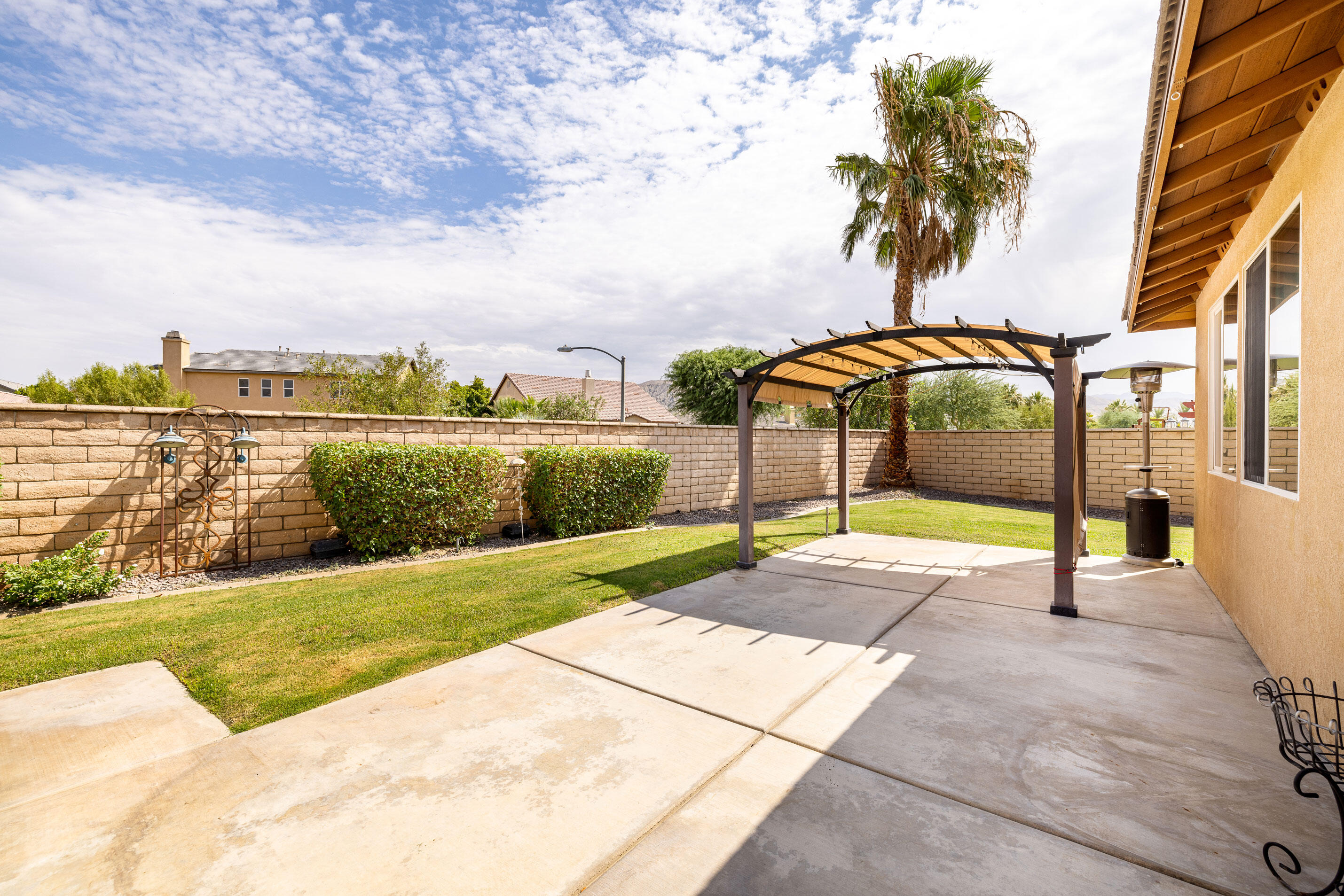 80292 Whitehaven Drive Indio, CA 92203 - Photo 18 of 25 a view of a swimming pool with a lawn chairs under an umbrella