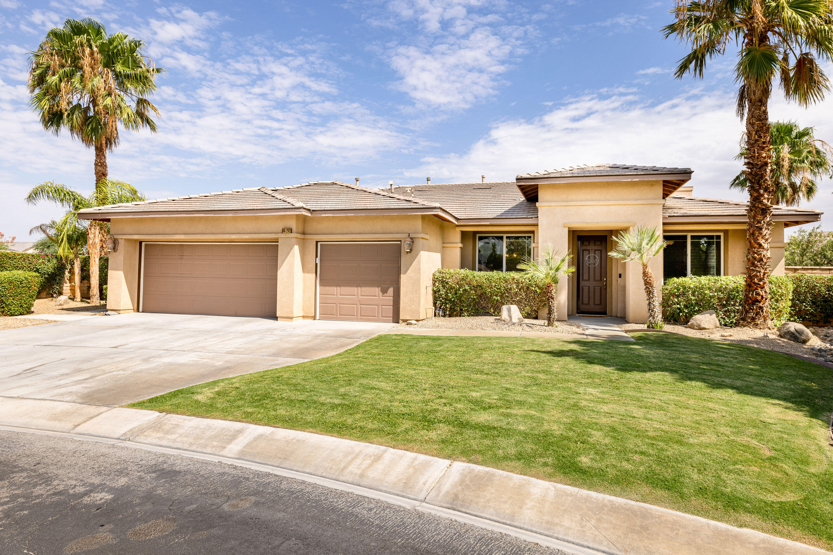 80292 Whitehaven Drive Indio, CA 92203 - Photo 2 of 25 a front view of a house with garden and trees