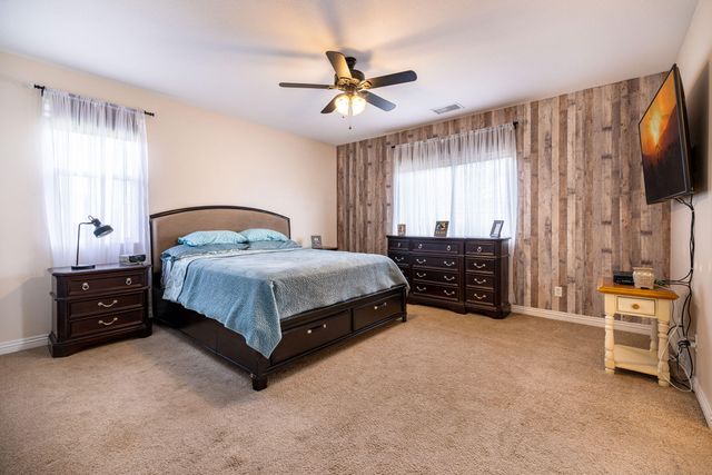 a living room with a bed furniture and a flat tv screen