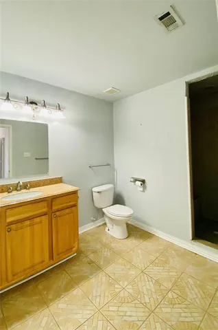 a bathroom with a granite countertop sink and a toilet