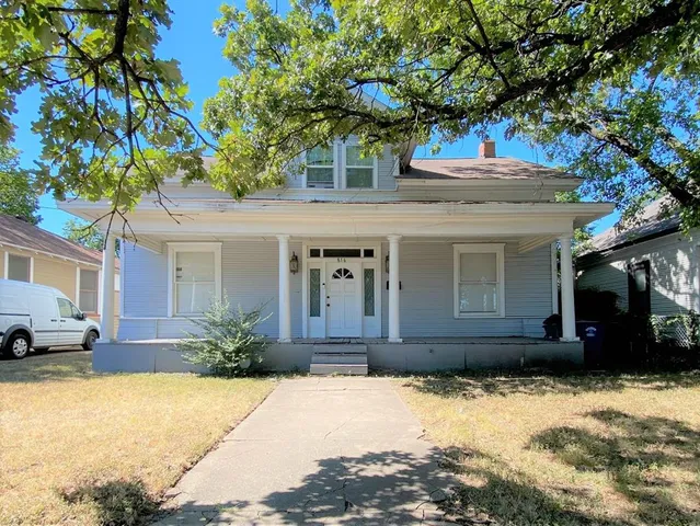 a front view of a house with a yard and a garage