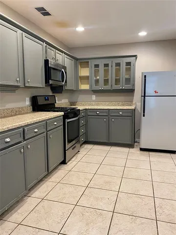 a kitchen with stainless steel appliances granite countertop a stove top oven a sink a counter top space and cabinets