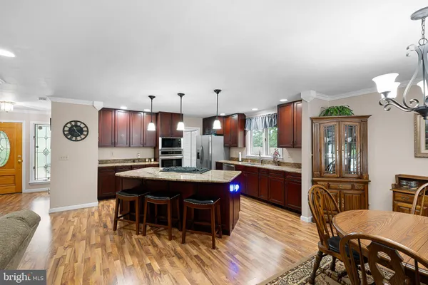 a dining room with furniture a chandelier and wooden floor