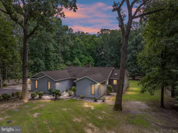 a view of a house with a yard and large tree
