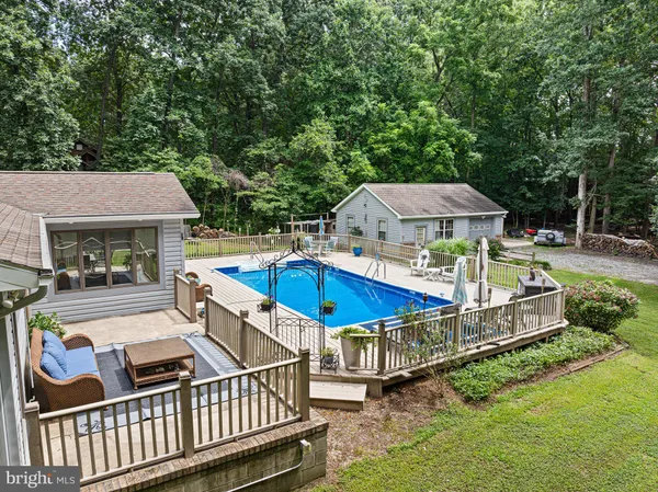 a view of a house with pool and chairs