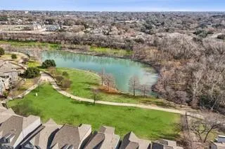 an aerial view of a house with a yard and lake view
