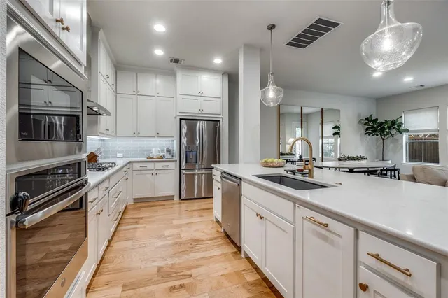 a kitchen with stainless steel appliances a sink stove and refrigerator