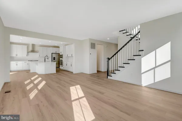 a large kitchen with stainless steel appliances kitchen island a stove a refrigerator a oven and a sink with cabinets