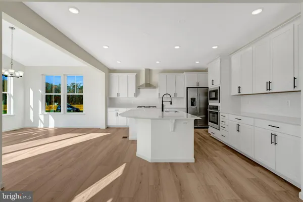 a kitchen with stainless steel appliances kitchen island granite countertop a refrigerator and a stove top oven