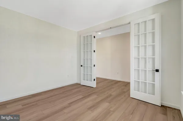 a view of an empty room with wooden floor fireplace and a window