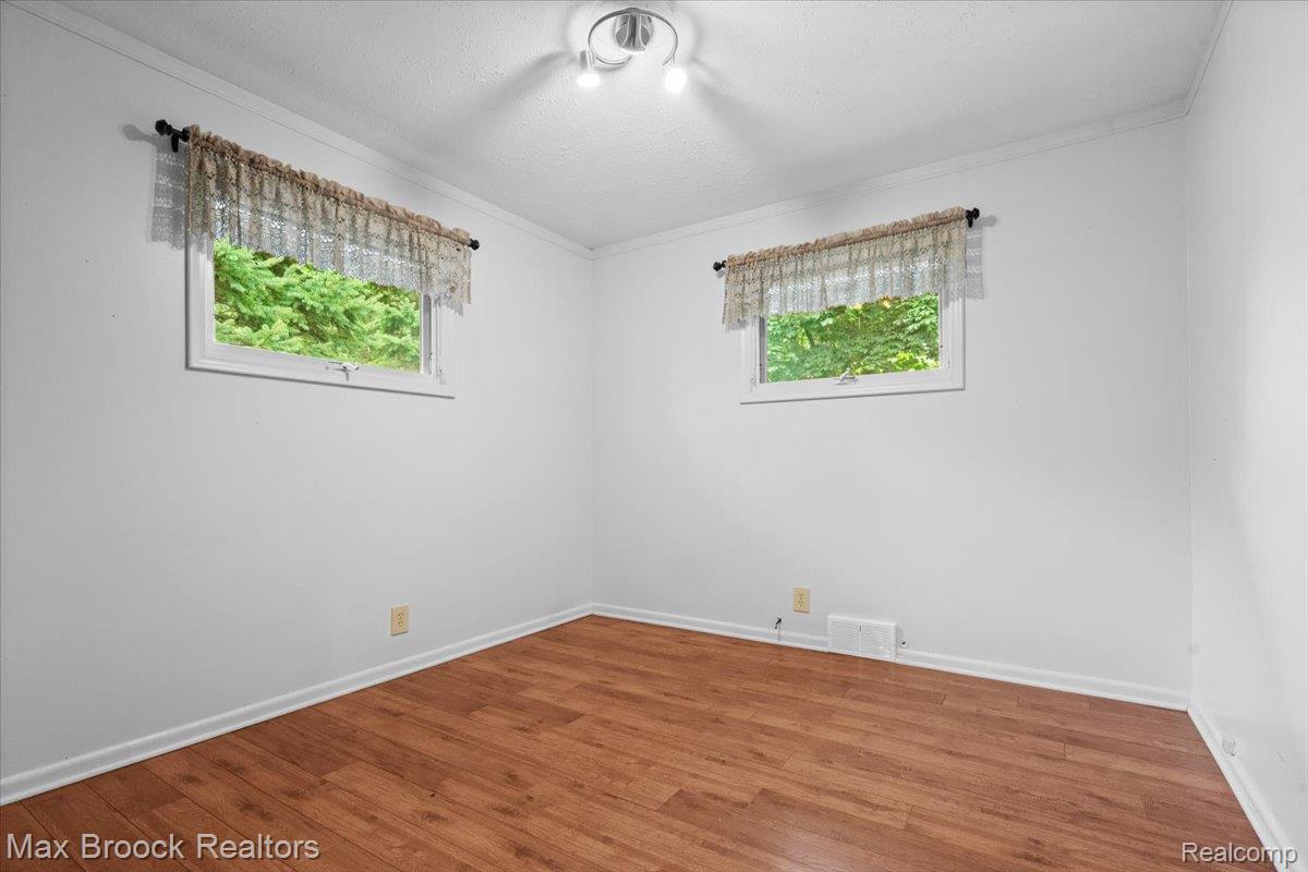 1330 Oak Street Rochester, MI 48307 - Photo 13 of 35 Wood-finish flooring with white baseboards, paired with white walls and ceiling