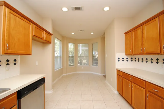a large white kitchen with a large window