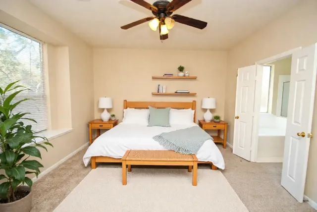 a bedroom with a bed and ceiling fan