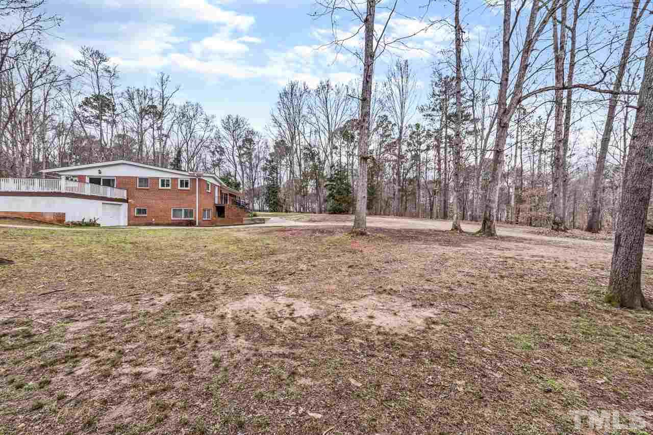 10217 Creedmoor Road Raleigh, NC 27615 - Photo 21 of 24 a large house with a big yard and large trees