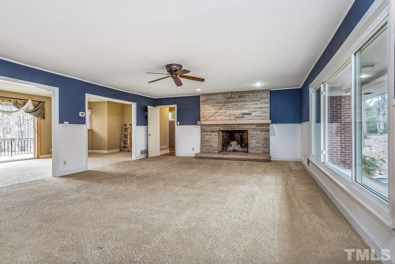 10217 Creedmoor Road Raleigh, NC 27615 - Photo 5 of 24 a view of an empty room with a fireplace and a window