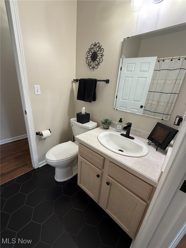 5645 Clingan Road, Unit 2D Struthers, OH 44471 - Photo 39 of 50 Bathroom featuring vanity, toilet, tile patterned flooring, and baseboards