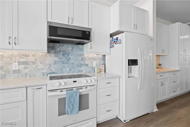 a kitchen with white cabinets and white appliances
