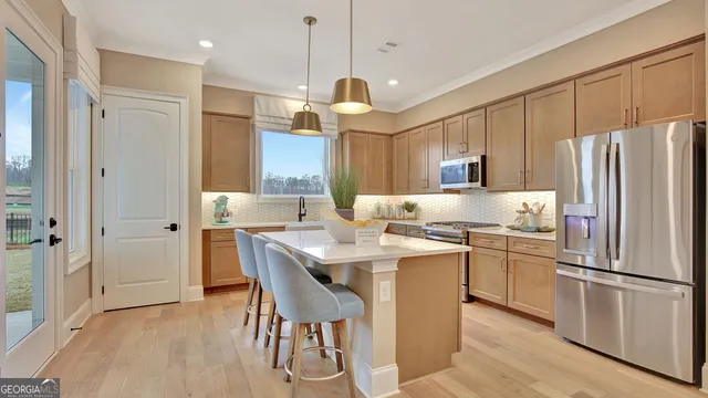 a kitchen with stainless steel appliances granite countertop a refrigerator a sink a stove and a refrigerator