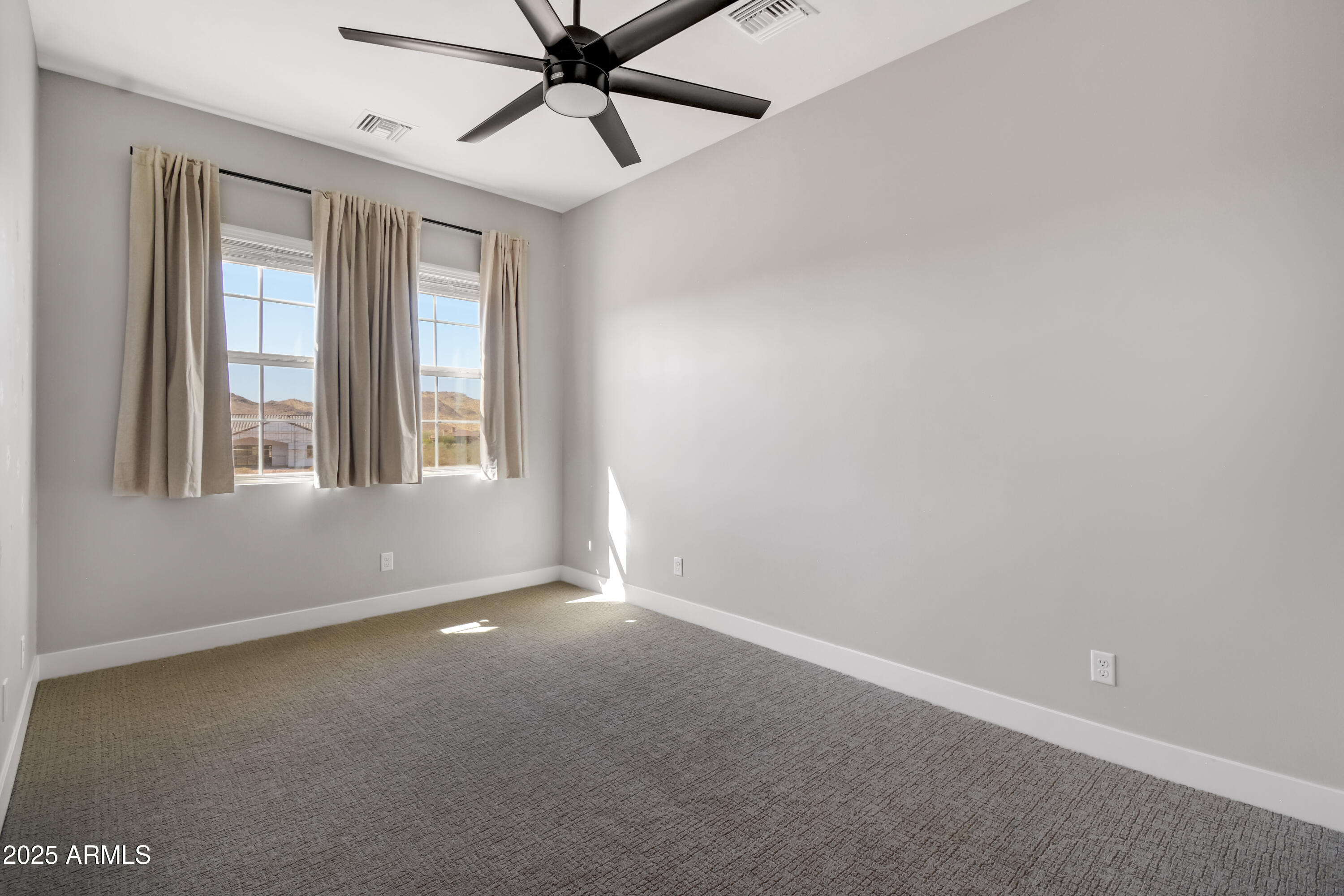 2775 South Baker Apache Junction, AZ 85118 - Photo 20 of 47 an empty room with windows and fan