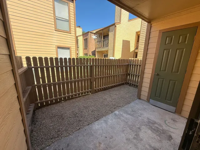 a view of a porch with a door and wooden fence