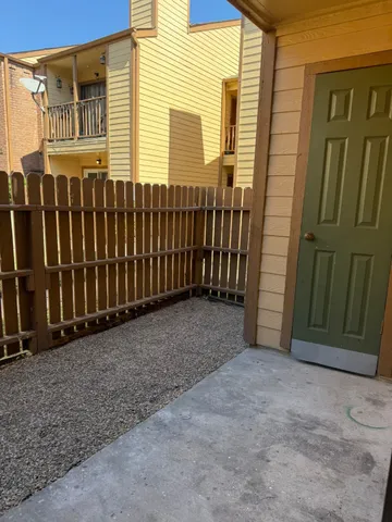 a view of a house with a wooden fence