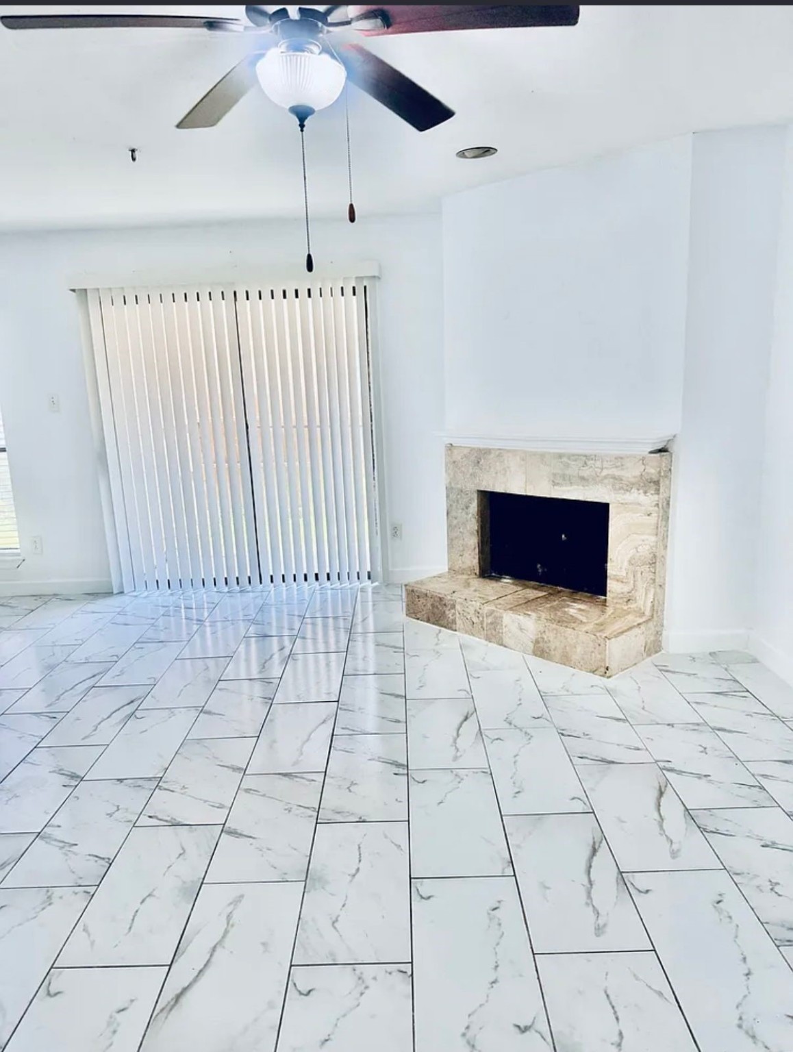 16111 Aspenglenn Drive, Unit 407 Houston, TX 77084 - Photo 6 of 15 a living room with a fireplace furniture a ceiling fan and a rug