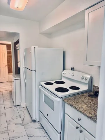a kitchen with white cabinets and white appliances