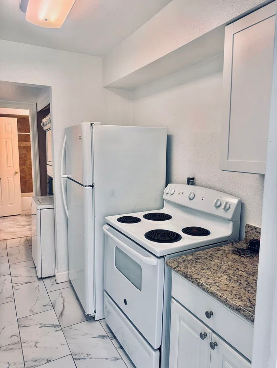 16111 Aspenglenn Drive, Unit 407 Houston, TX 77084 - Photo 8 of 15 a kitchen with white cabinets and white appliances