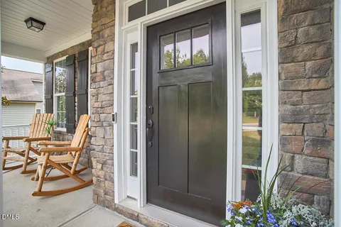a view of a balcony with chairs and front door
