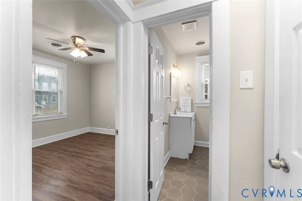 a view of a hallway with a chandelier fan and wooden floor