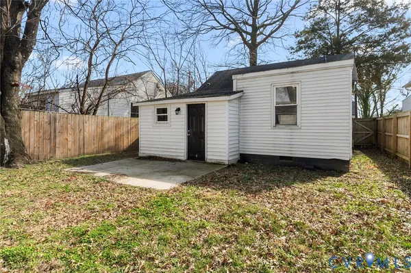 a view of a house with a yard and wooden fence