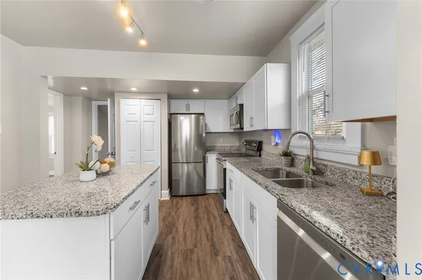 a kitchen with stainless steel appliances granite countertop a sink stove and refrigerator
