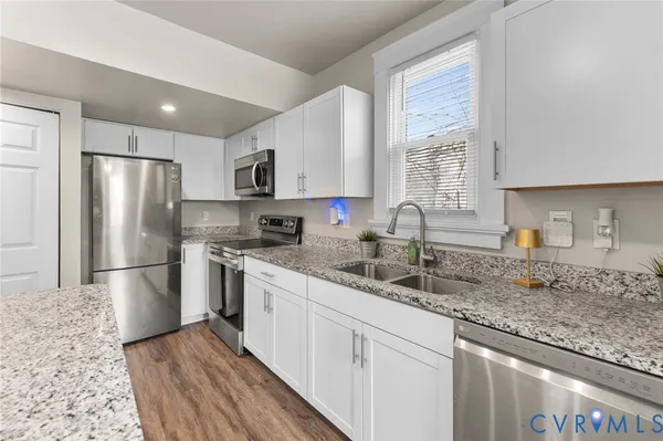 a kitchen with stainless steel appliances granite countertop a sink stove and refrigerator