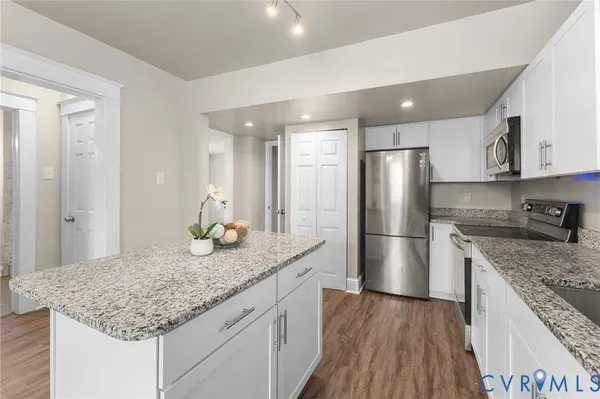 a kitchen with stainless steel appliances granite countertop a sink stove and refrigerator