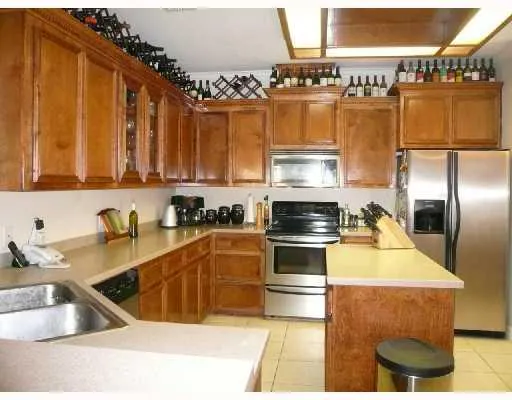 a kitchen with stainless steel appliances granite countertop a sink a stove and a refrigerator