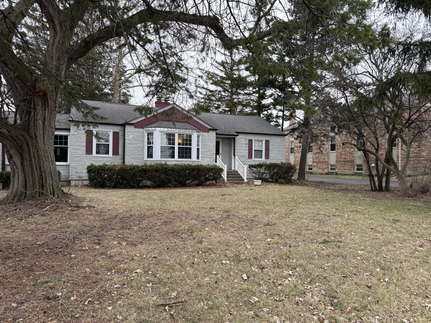 a front view of a house with a garden and trees