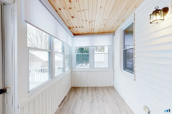 a view of a hallway with wooden floor and windows