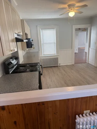 a large kitchen with hardwood floor and a ceiling fan
