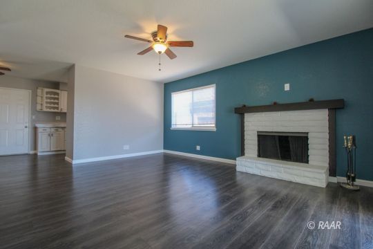 420 Lenore Street Ridgecrest, CA 93555 - Photo 6 of 29 a view of an empty room with wooden floor fireplace and a window