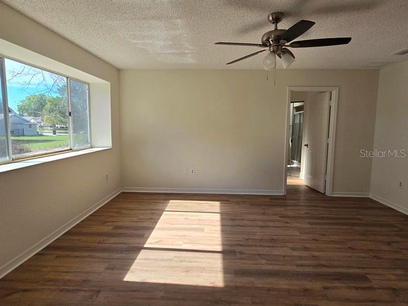 11510 Southwest 85th Court Ocala, FL 34481 - Photo 14 of 39 a view of an empty room with wooden floor and a window