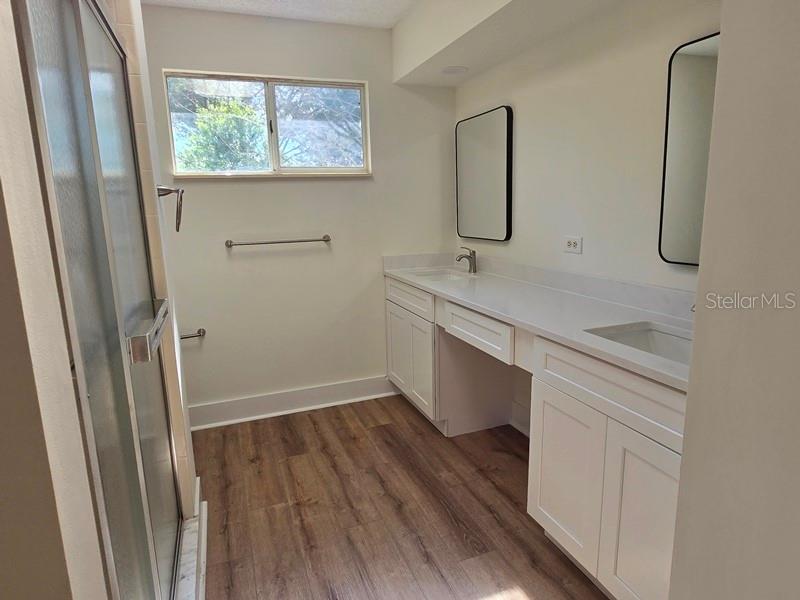11510 Southwest 85th Court Ocala, FL 34481 - Photo 17 of 39 a bathroom with a sink and mirror with wooden floor