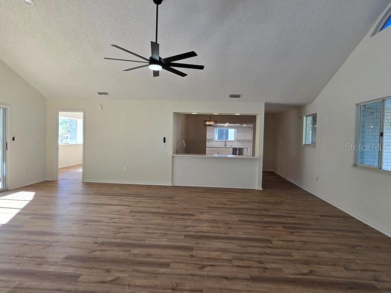 11510 Southwest 85th Court Ocala, FL 34481 - Photo 23 of 39 a view of a livingroom with wooden floor a ceiling fan and windows