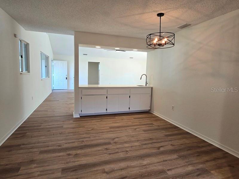11510 Southwest 85th Court Ocala, FL 34481 - Photo 7 of 39 a view of a room with wooden floor and chandelier