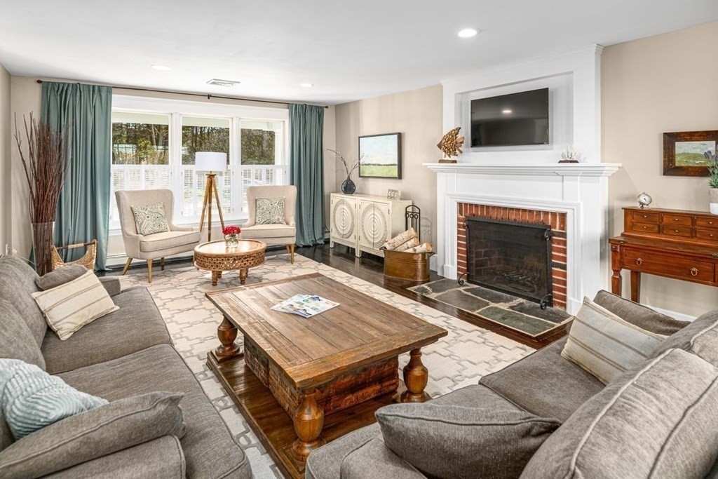3 Cricket Circle Scituate, MA 02066 - Photo 13 of 42 a living room with a couch a flat screen tv and a fireplace